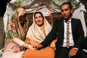 عمه داماد دست عروس و داماد را گرفته و ترانه ای را به زبان ترکمنی برایشان می خواند