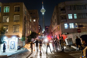 عکس منتخب سال - ۲۴ اسفند - جمعی از مردان «زن پوش» براساس سنتی دیرین در برخی از محله‌های تهران درگروه‌های پنج و شش نفره در مراسم چهارشنبه‌سوری به قاشق‌زنی پرداختند این افراد به در منازل رفته و با قاشق به ظرف‌های خالی می‌زدند و از صاحبخانه شیرینی و آجیل دریافت می‌کردند و در مقابل به صاحبخانه کاغذی درباره رسم کهن چهارشنبه‌سوری و قاشق‌زنی می‌دادند و برای اهل خانه آرزوی سالی خوش و نوروزی فرخنده می‌کردند.