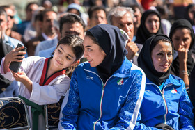 عکس منتخب سال - ۶ شهریور، کرج. دختربچه ورزشکار با کیمیا علیزاده -برنده مدال المپیک- در مراسمی که برای تقدیر از او برپا شده عکس سلفی می گیرد.