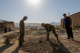 مردم منطقه و سربازان ارتش در حال دفن جسد احشام و پرندگانی هستند که در زیر آوار زلزله تلف شده اند.