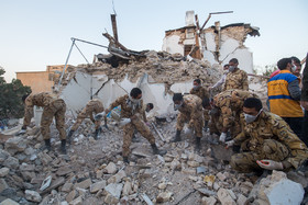 سربازان ارتش مشغول پاکسازی منطقه از مصالح و نخاله‌های ساختمانی هستند که در اثر زلزله به‌وجود آمده‌اند.