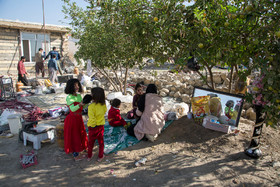 زلزله‌زدگان روستای کوییک حسن در بین خرابی‌های خانه خود نشسته‌اند.