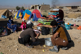 پدر و پسر در حال شستشو و نظافت در روستای کوییک حسن در اطراف شهرستان سر پل ذهاب هستند.