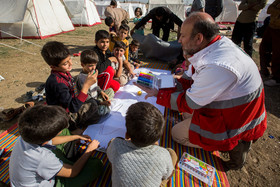 روانشناس هلال احمر در حال بازی با کودکان زلزله زده سرپل ذهاب است.