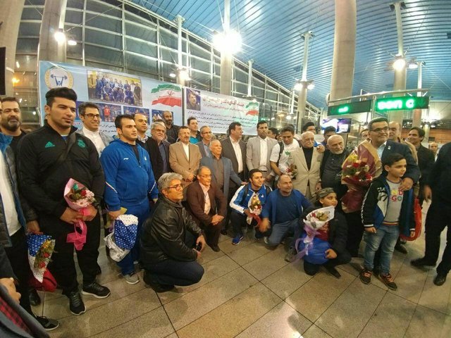 بازگشت تیم ملی وزنه برداری به ایران/ پخش شیرینی در فرودگاه توسط خانواده علی حسینی