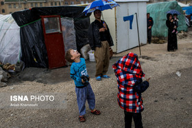 یک از کودکان مصدوم زلزله‌زده محله زعفران در شهرستان سرپل‌ذهاب، خوشحال از بارش باران در این منطقه بازی می‌کند. بیش از دو ماه بعد از وقوع زلزله در استان کرمانشاه، برف، باران و سرمای هوا شرایط سختی را برای مردمانی که در چادر و کانکس زندگی می‌کنند رقم زده است. حالا باران آمده، کودک خرسند است و پدر، نگرانِ سرپناه خانواده.