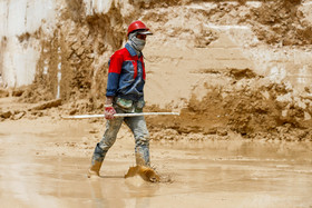 بارش باران و گل آلود شدن کف معدن که کار را برای کارگران سخت می کند.