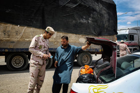 یکی از نیروهای مرزبانی ایران در حال بررسی و کنترل مدارک راننده افغان است.