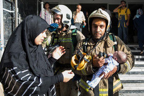 مادر نوزاد نجات یافته در آتش‌سوزی مجتمع مسکونی «پارامیس»، فرزند خود را در آغوش میکشد