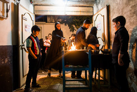 ساکنان کوچه، منبرهای کوچک مخصوص روضه را جلوی در خانه می گذارند و روی آن مجمری از آتش و دو ظرف خالی و یک ظرف برنج خام قرار می دهند.