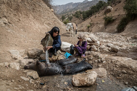 یکی از زنان روستاهای زلقی غربی مشک‌های درست شده از پوست حیوانات را برای مصرف آشامیدن از آب چشمه پر می‌کند تا آنجا را با الاغ به خانه ببرد.