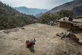 یکی از کودکان روستای چافره که در پشت بام آغل حیوانات دراز کشیده است.