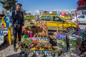 رضا ۲۶ ساله ۵ سالی است که مغازه گلفروشی دارد و به امید فروش بیشتر در این روزها گل هایش را به مرکز شهر آورده است 

