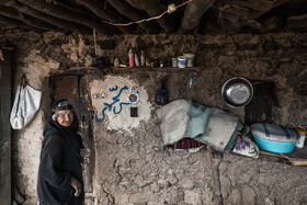 زنی کهنسال از روستای پز علیا در ایوان منزل خود. خانه های روستایی اکثرا از سنگ و گل و سقف آن از چوب و گِل ساخته شده است.