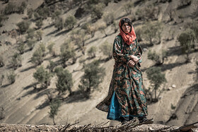یکی از زنان روستای ذلقی شرقی بر پشت بام خانه خود.
