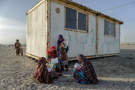 دختران روستای کیدر قدیم در حیاط مدرسه در حال دادن امتحان املا هستند.