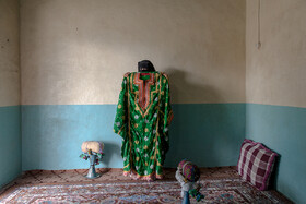 فاطمه کوپشی لباس عروسی خود را که با هنر زری بافی دست خود دوخته است نشان میدهد.