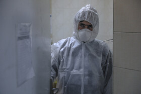 کارمندان با لباس مخصوص در مرکز قرنطینه بیماران و در اتاق ایزوله رفت و آمد می‌کنند