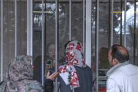 خانواده‌های این دو بیمار بستری در مرکز قرنطینه بیمارستان یافت‌آباد، از طریق راهروی بیرونی اتاق ایزوله با بیمارشان دیدار می‌کنند