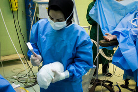یکی از اعضای تیم جراحی در حال خردکردن یخ برای انتقال قلب است. 