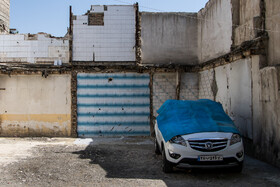 ماشین پارک شده در سایه خانه های تخریب شده ده ونک 