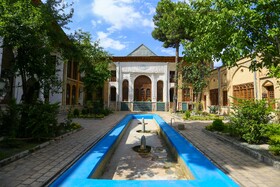 پس از سردر ورودی فضای هشتی قرار دارد که در دیواره های این فضا، طاقچههایی ایجاد شده و سقف آن با رسم بندیهای آجری تزیین شده و پس از هشتی دالان نسبتا درازی قرار دارد که به حیاطی اصلی تکیه منتهی میشود.