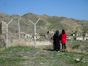 خانواده های که به در روستاهای منطقه خداآفرین آمده‌اند و روستای تخریب شده و عاری از سکنه در آنسوی مرز را تماشا می کنند