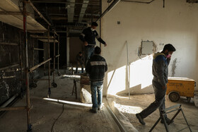 کارگران در حال تکمیل کردن تجهیزات داخلی ساختمان هستند.
