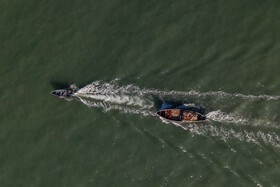 قایق حمل تور توسط یدک کش از ساحل فاصله میگیرند تا از آنجا تور ها پخش شوند