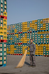 یکی از کارکنان کارخانه که به گفته خودش به صورت موقت حیاط محوطه را جارو میکند.