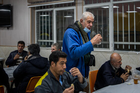 کارکنار کارخانه در حال خوردن صبحانه در محل غذاخوری هستند.