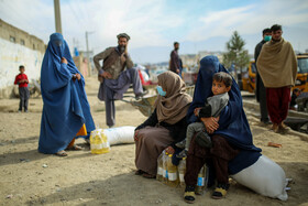 زبیده که ۲۲ سال سن دارد بههمراه فرزندش پس از دریافت سبد غذایی که سازمان جهانی غذا در دوره دوم تحویلشان نموده به انتظار همسرش برای جابجایی این اقلام است.