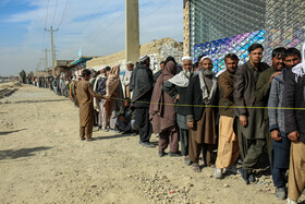 مردان سرپرست خانواده اهل کابل در انتظار بررسی کارت شناسایی صادر شده از جانب سازمان جهانی غذا برای دریافت سبد غذایی شان هستند.