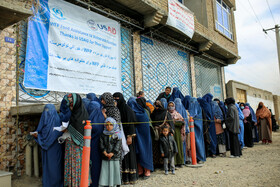 زنان سرپرست خانواده اهل کابل در انتظار بررسی کارت شناسایی صادر شده از جانب سازمان جهانی غذا برای دریافت سبد غذایی دوره اول شان هستند.