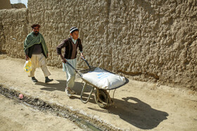 یکی از سرپرستهای خانواده بههمراه فرزندش در حال بردن سهمیه به سمت خانه هستند.