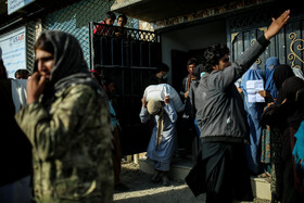 یکی از نیروهای بخش برقراری امنیت امارت اسلامی در حال تذکر به افرادیست که نظم صفوف دریافت سبد غذایی از طرف سازمان جهانی غذا است.