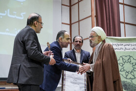 تجلیل از علامه جوادی آملی به عنوان استاد خادم کتاب و اهدای لوح و تقدیرنامه به فرزند او، مرتضی که در نبود پدر لوحش را گرفت