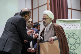 تجلیل از علامه جوادی آملی به عنوان استاد خادم کتاب و اهدای لوح و تقدیرنامه به فرزند او، مرتضی که در نبود پدر لوحش را گرفت