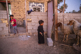 فرزندان کوچک خانواده مشتاق در پشت خانه و در کنار آغل گوسفندان