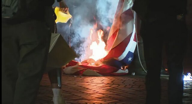 معترضان به قانون مهاجرت در سیاتل، پرچم آمریکا را آتش زدند