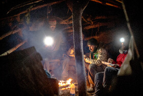 داوطلبان در کلبه‌ چوبی با آتش خود را گرم می‌کردند. 