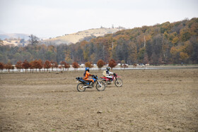موتورسواران در حاشیه دریاچه خالی‌شده؛ تردد بر زمینی که زمانی بستر آب بود.