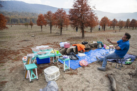 گردشگران در میان درختان پاییزی کنار دریاچه؛ جایی که خشکی امسال بیش از همیشه خود را نشان می‌دهد.