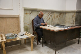 برش آیینه‌ها برای تزیین رواق‌های حرم توسط کارگران در حال انجام است.