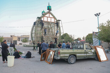 آیینه ها برای نصب در جلوی نقل توسط جوانان به بالای نقل فرستاده می‌شود.
