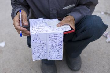 یکی از علاقه‌مندان مسابقات اسبدوانی پیش از آغاز کورس، در حال انجام مراحل شرط‌بندی و انتخاب اسب مورد نظر خود برای رقابت است.