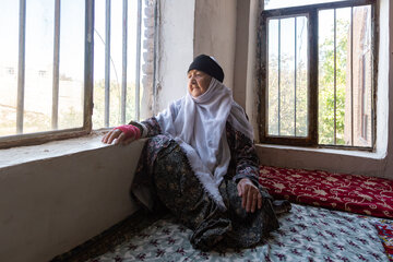 یکی از ساکنان روستا در فضای داخلی خانه‌اش و در کنار پنجره در فصل تابستان.
