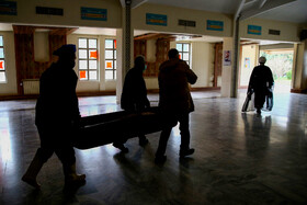 خانواده یک متوفی کرونایی به همراه پرسنل آرامستان در حال تشییع پیکر عزیز خود از داخل سالن تطهیر به بیرون هستند تا برای رعایت اصول بهداشتی، نماز وی را خارج از سالن نمازخانه و در محیط باز اقامه کنند.