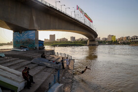 کودکان منطقه عامری در فصل تابستان برای فرار از گرما در رودخانه کارون شنا می کنند.