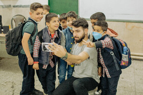 پوریا در حال سلفی گرفتن در آخرین روز مدرسه با دانش آموزانش که هشت ماه با آنها وقت گذرانده